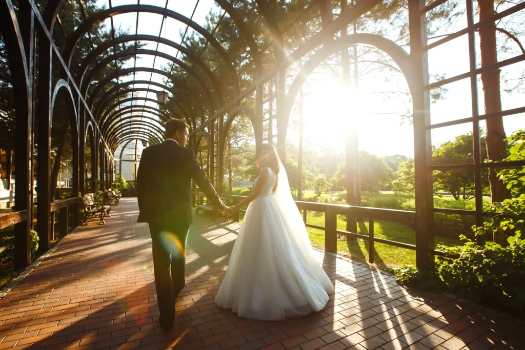 Pareja de recién casados caminando por un jardín